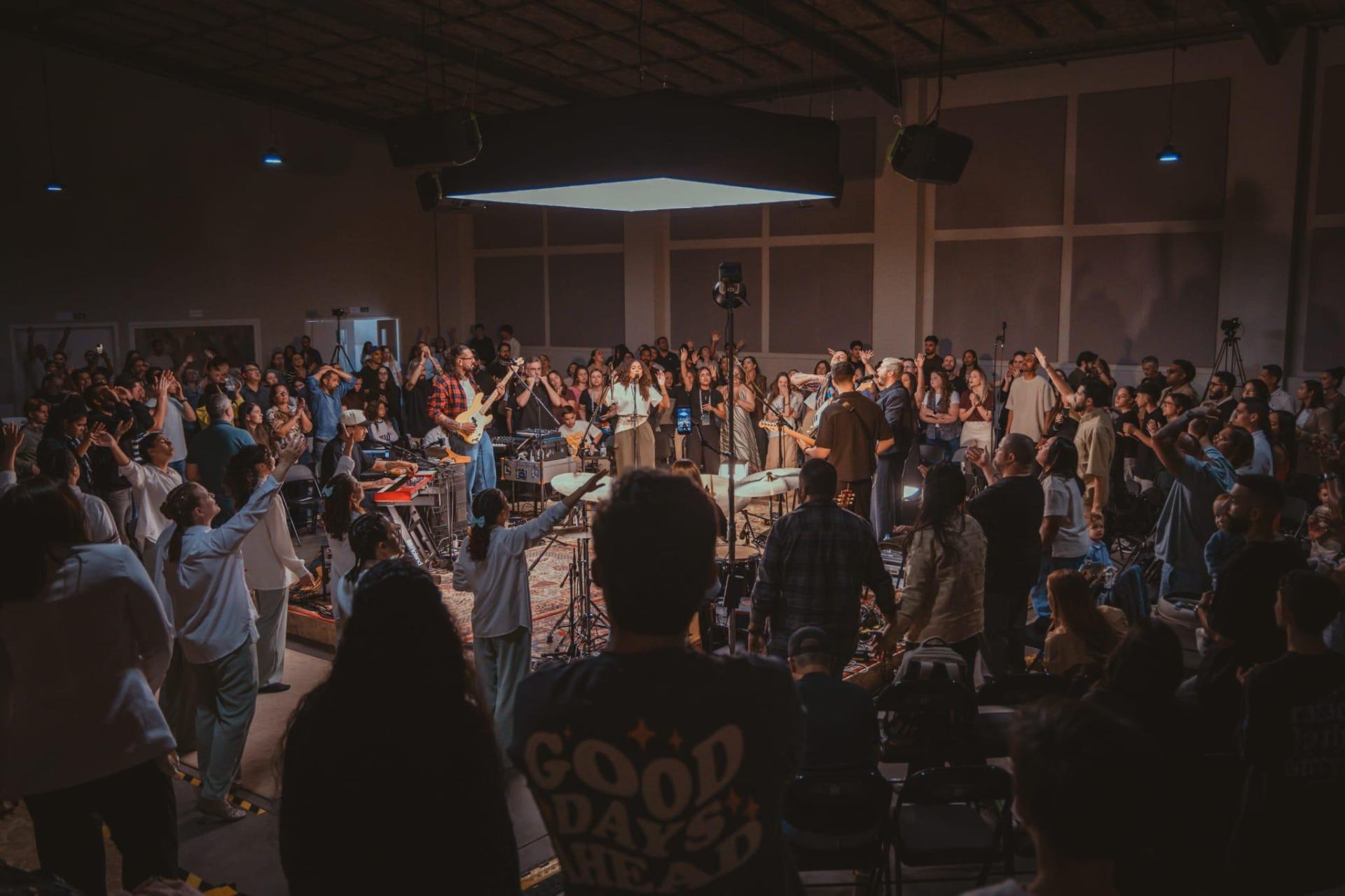 Congregação com as mãos levantadas em adoração no Ajuntamento Maranata